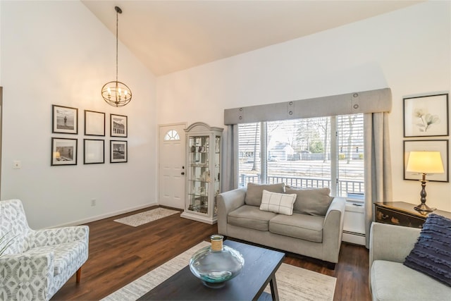 living area with high vaulted ceiling, a baseboard heating unit, baseboards, dark wood finished floors, and an inviting chandelier