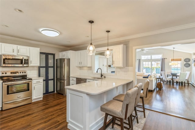 kitchen with white cabinetry, stainless steel appliances, a sink, and light countertops