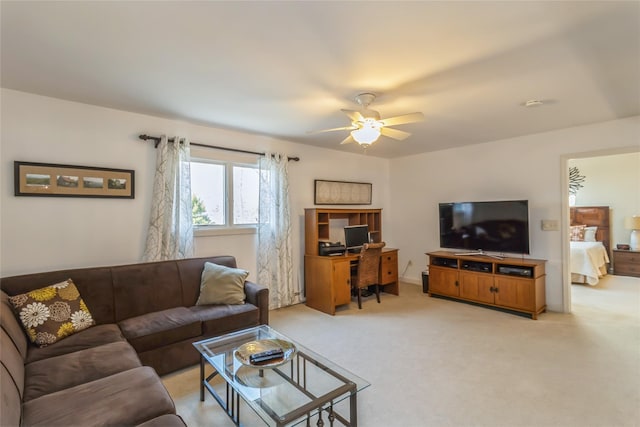 living area featuring light carpet and ceiling fan