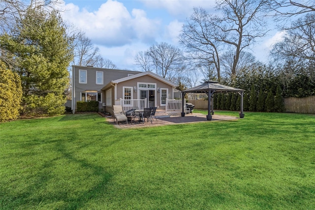 rear view of property with fence, a lawn, a gazebo, and a patio