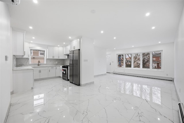 kitchen with white cabinets, a baseboard radiator, appliances with stainless steel finishes, marble finish floor, and recessed lighting