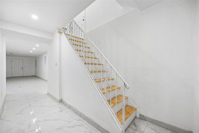 staircase featuring baseboards, marble finish floor, and recessed lighting