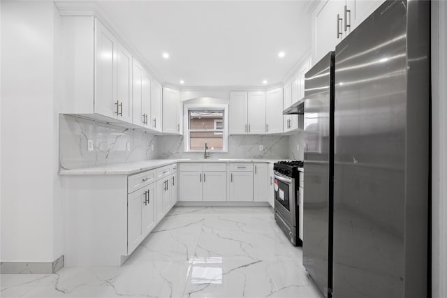 kitchen with marble finish floor, stainless steel appliances, decorative backsplash, white cabinetry, and a sink