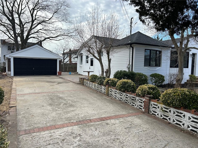 view of side of property with roof with shingles, an outdoor structure, fence, and a detached garage