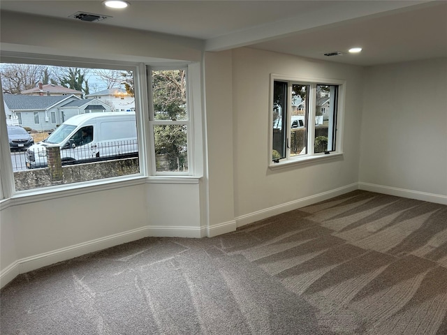 carpeted empty room featuring baseboards, visible vents, and recessed lighting