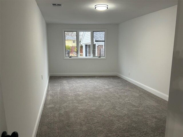 carpeted empty room featuring baseboards and visible vents