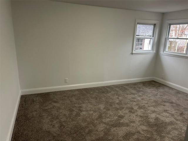 spare room featuring carpet and baseboards