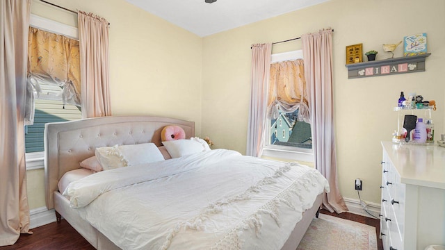 bedroom featuring multiple windows, baseboards, and dark wood-style flooring