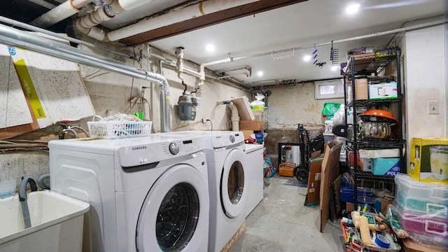 washroom with laundry area, a sink, and washing machine and clothes dryer