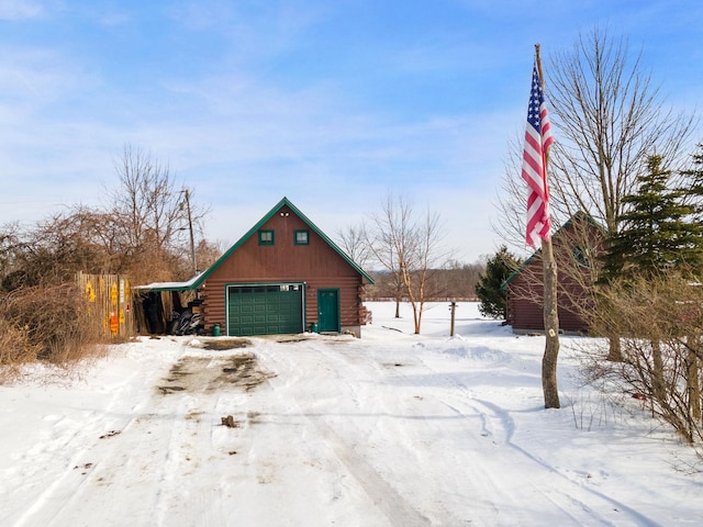 snow covered garage with a detached garage