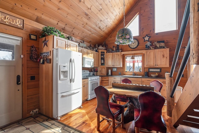 kitchen featuring white appliances, a sink, and wooden walls