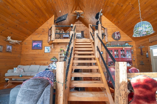 stairs with wood ceiling, vaulted ceiling, and wooden walls