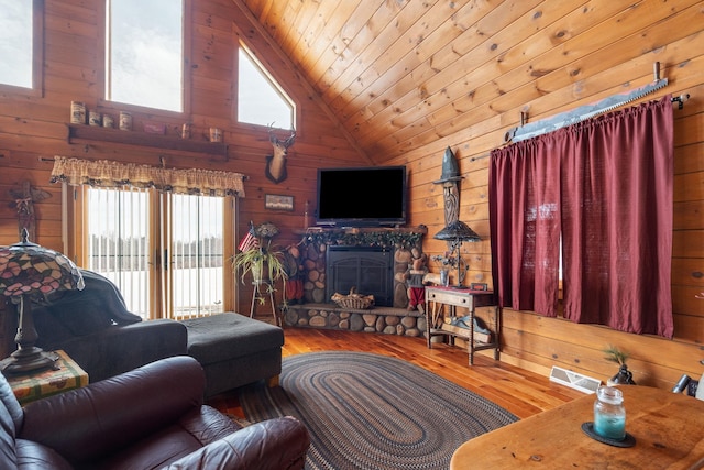 living area featuring wooden ceiling, wood walls, a fireplace, and a wealth of natural light