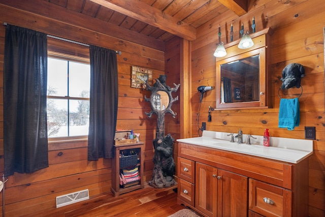 bathroom featuring wood ceiling, wooden walls, visible vents, and beamed ceiling