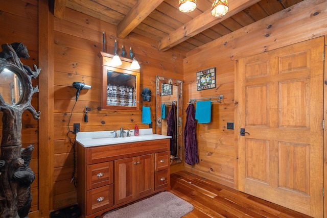 bathroom featuring wooden ceiling, beamed ceiling, wood walls, and vanity