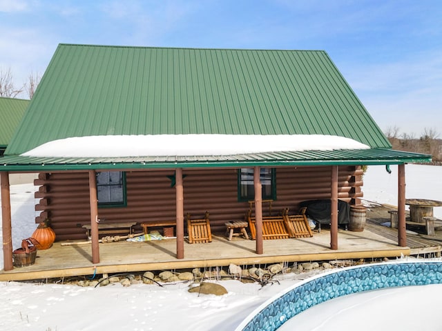 rear view of house with metal roof, log siding, and a wooden deck