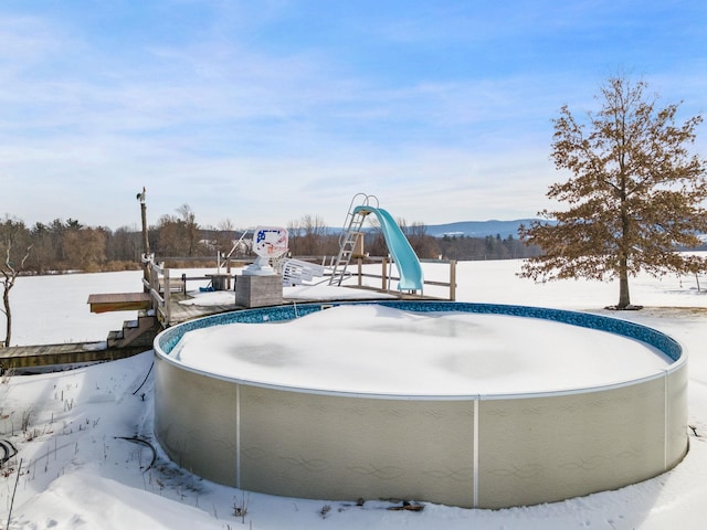 snow covered pool featuring a water slide