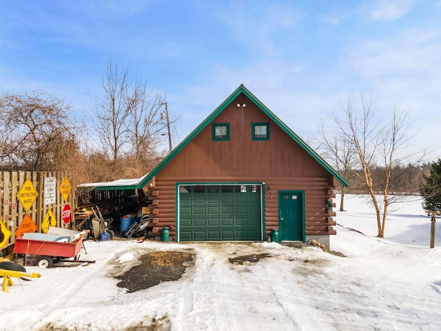 snow covered garage featuring a detached garage