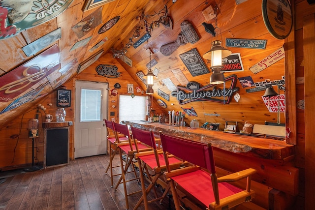 bar featuring lofted ceiling, hardwood / wood-style flooring, wooden walls, and a dry bar