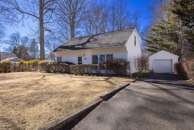 view of side of property featuring an outbuilding, driveway, and a detached garage