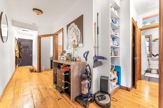 hallway featuring light wood-style flooring and baseboards