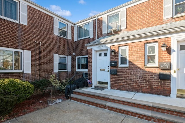 entrance to property featuring brick siding