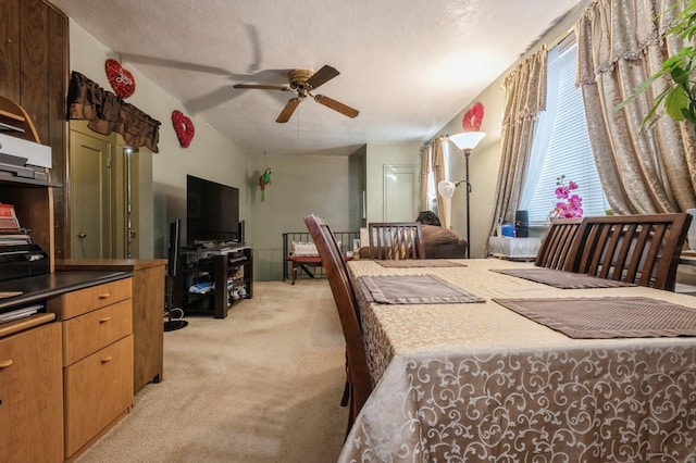 bedroom with light colored carpet, ceiling fan, and a textured ceiling