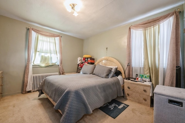 bedroom featuring radiator, baseboards, and light colored carpet