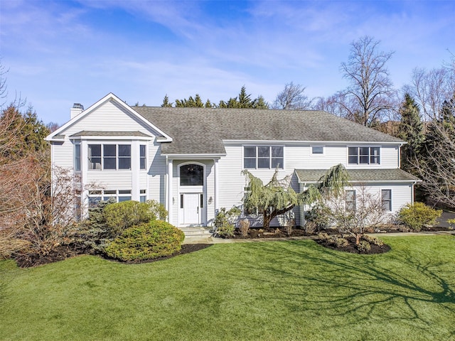 view of front of home featuring roof with shingles, a chimney, and a front lawn