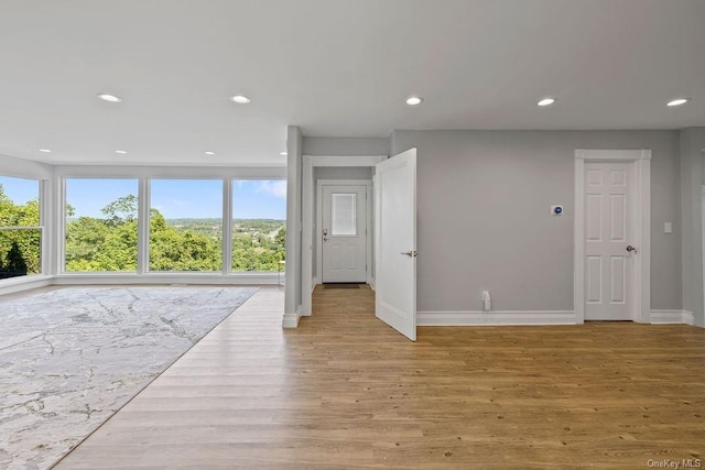 interior space featuring baseboards, light wood-style flooring, and recessed lighting