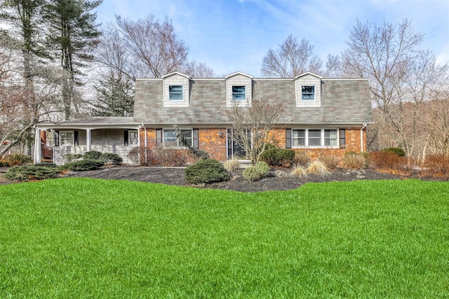 view of front of house with a front yard and brick siding