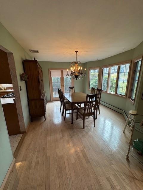 dining area featuring light wood-style flooring, visible vents, and a notable chandelier