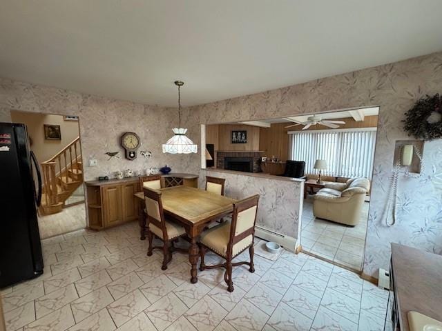 dining room with marble finish floor, a fireplace, stairway, and a ceiling fan