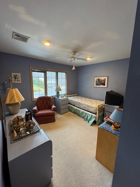 carpeted bedroom with visible vents and a ceiling fan