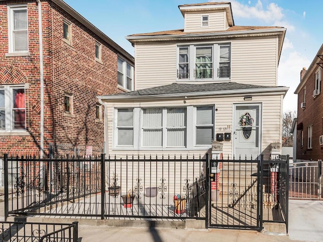 american foursquare style home featuring a fenced front yard and a gate