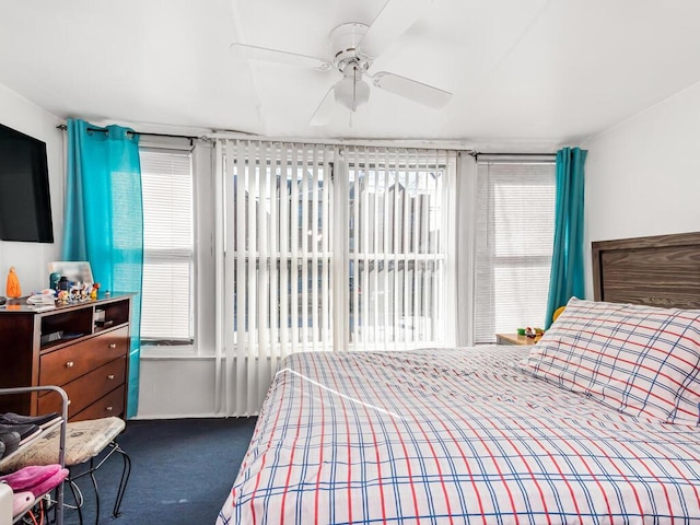 bedroom featuring a ceiling fan, multiple windows, and carpet flooring