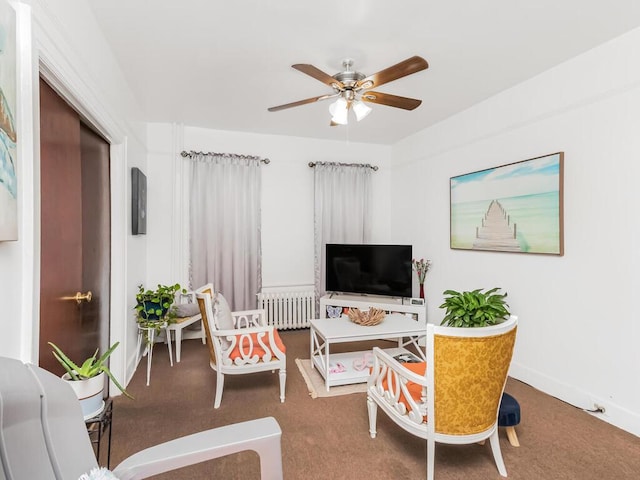 carpeted living area with baseboards, a ceiling fan, and radiator