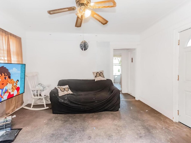 sitting room featuring unfinished concrete floors and a ceiling fan