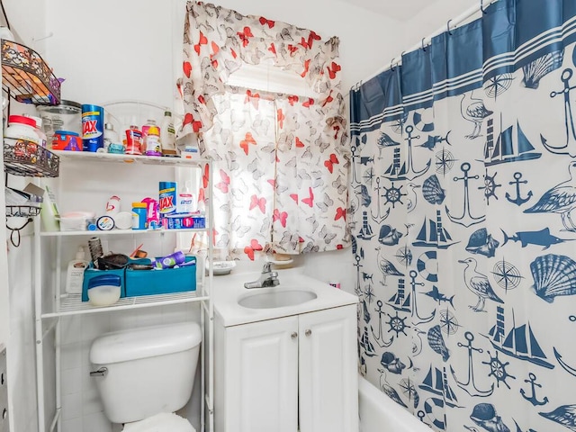 full bath featuring toilet, shower / bath combo with shower curtain, and vanity