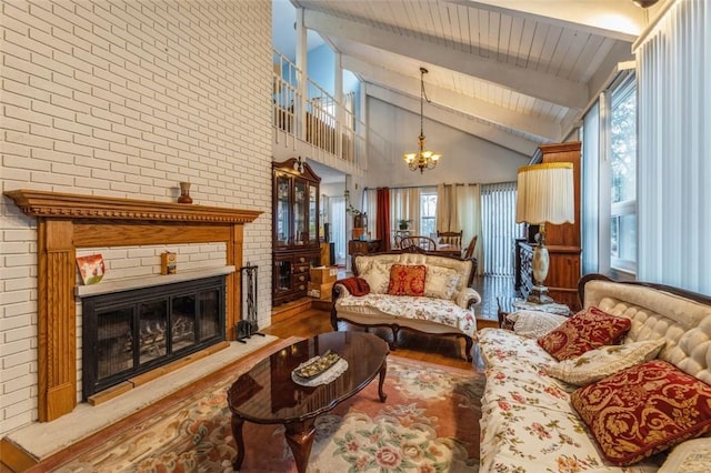 living area featuring plenty of natural light, a fireplace, wood finished floors, and a chandelier