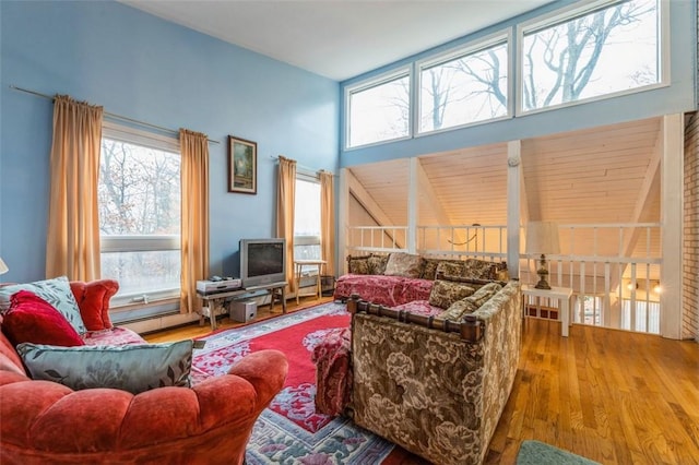 living area with a high ceiling and wood finished floors