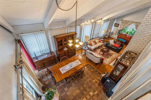 living area featuring beamed ceiling and an inviting chandelier