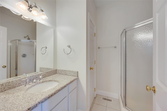 bathroom featuring tile patterned flooring, visible vents, vanity, baseboards, and a shower stall