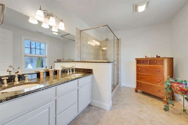 bathroom with double vanity, a stall shower, and a sink