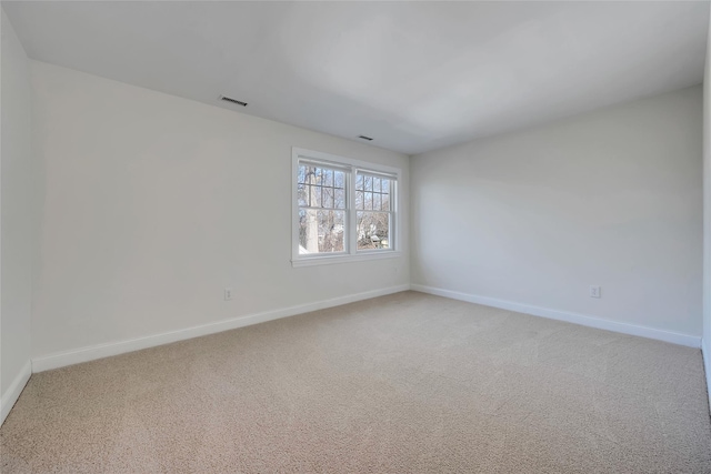 empty room with light carpet, visible vents, and baseboards