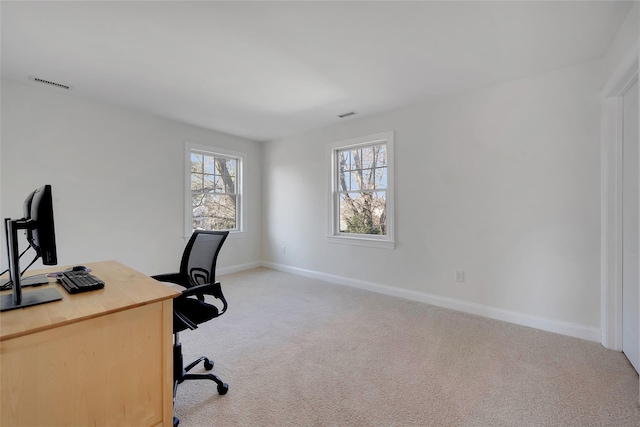 home office with baseboards, visible vents, and light colored carpet