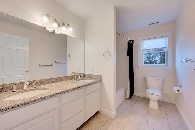 bathroom with toilet, tile patterned flooring, double vanity, and a sink