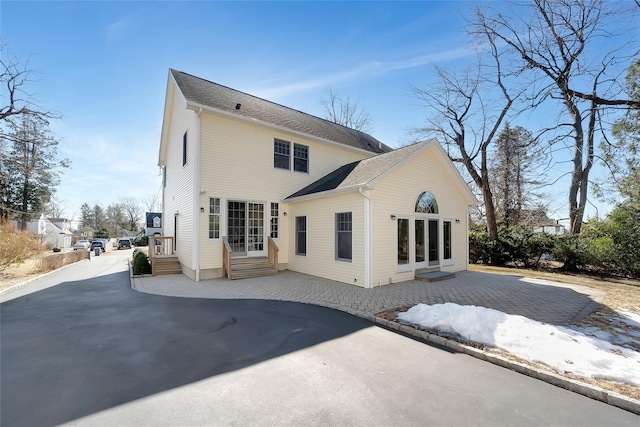 rear view of house featuring entry steps and driveway