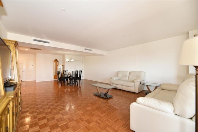 living room featuring visible vents and a chandelier