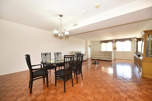 dining space with visible vents, baseboards, and an inviting chandelier